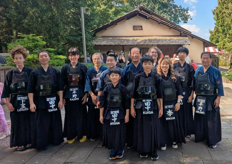 Image of DKD members from the festival in front of the Saginaw Japan Garden Teahouse